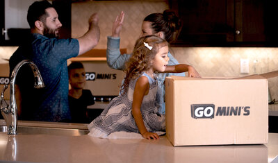A happy family in a ktichen with Go Mini's moving boxes on counters